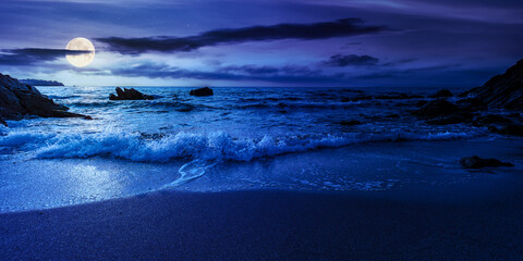 Wall Mural - empty beach at night. beautiful landscape at the sea. waves washing the sand and stones on the shore