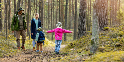 Wall Mural - active young family with two children spend time together on a walk in forest. copy space