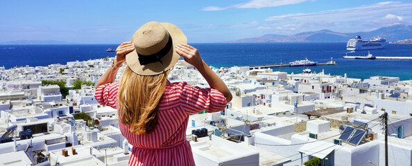 Wall Mural - Panoramic view of a tourist girl looking at cruise ship that docks in the port of Mykonos, Cyclades Islands, Greece