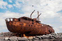 Plassey Shipwreck On Shore Of Inisheer Island. Aran Islands, County Galway, Ireland. Rough Stone Coast And Blue Cloudy Sky. Popular Tourist Landmark And Attraction. Irish Landscape