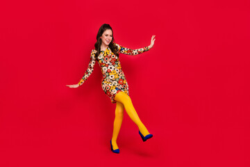 Full length body size view of attractive cheerful girl dancing having fun rest isolated over bright red color background