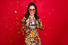 Portrait Of Attractive Cheerful Girly Girl Holding Silver Disco Ball Having Fun Isolated Over Bright Red Color Background