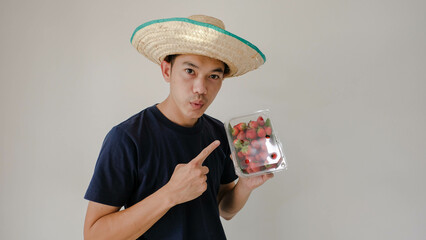 Man holding a box of strawberries. Please Mot. Strawberry fruit souvenirs.