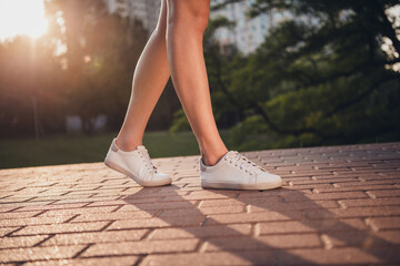 Poster - cropped photo of woman legs step walk path near building complex free time outside