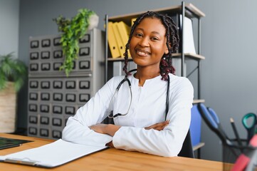 Wall Mural - Portrait Of Smiling Female Doctor Wearing White Coat With Stethoscope In Hospital Office.