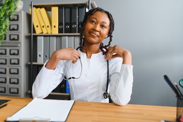 Wall Mural - Portrait Of Smiling Female Doctor Wearing White Coat With Stethoscope In Hospital Office.