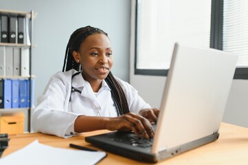 Wall Mural - healthcare, medical and technology concept - african female doctor with laptop