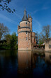 Rounded brick fortified tower and remains of picturesque Duurstede castle with access bridge over the moat surrounding the fortress reflecting in the water in the foreground