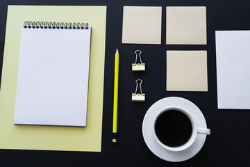 Wall Mural - flat lay of cup with coffee near sticky notes, pencil and notebook on black.