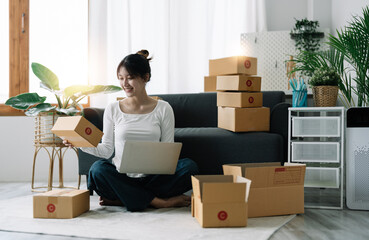 Wall Mural - Portrait of Starting small businesses SME owners female entrepreneurs working on receipt box and check online orders to prepare to pack the boxes, sell to customers, SME business ideas online