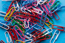 Close Up View Of Colorful Paper Clips On Blue.