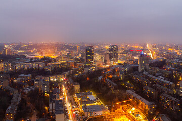 Wall Mural - Ukraine, Kyiv – March 12, 2016: Aerial panoramic view on central part of Kyiv city from a roof of a high-rise building. Night life in a big city. Foggy and rainy weather. 