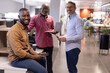 © WavebreakMediaMicro - Portrait of smiling multiracial male business colleagues with wireless technologies at modern office
