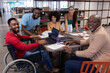 © WavebreakMediaMicro - Portrait of smiling multiracial male and female advisors in boardroom during meeting