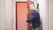 Attractive man open door and show way out with strict gesture
