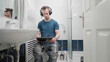 © Video_StockOrg - Bathroom with man watching movie on tablet with headphones