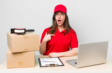 young pretty woman  looking shocked and surprised with mouth wide open, pointing to self. company packer employee