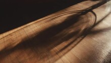 Close-up Of Shadow Of Electric Fan Rotating On Brown Wooden Floor Backgrounds