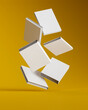 © Vladislav - white books falling on a yellow surface. Blank book cover. layout or template. 3d render