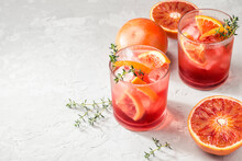 Red Cocktail In Base Of Campari Or Bitter With  Sicilian Red Oranges (tarocco) On Light Gray Concrete Background, Copy Space. Aperitif With Americano Cocktail. Natural Eco  Aesthetic, Summer Light
