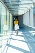 © WavebreakMediaMicro - Full length of african american businesswoman talking on smartphone walking with mug in corridor
