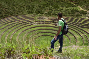 A person on the territory Inca terraces of Moray. Moray is an archaeological site near the Sacred Valley