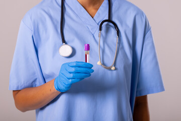 Wall Mural - Midsection of african american mid adult female doctor wearing glove holding test tube with blood