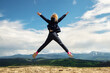 © Kyryl Gorlov - Back view of cute little blond baby girl excited kid jumping walking on scenic carpathian mountain peaks hill valley at summer adventure top outdoor camp. Nature travel freedom concept