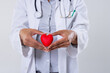 Midsection of african american mid adult female doctor holding red heart against white background