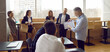 © Studio Romantic - Team of people gather in modern office and have lesson with business teacher. Group of adult male and female students having training class with experienced coach who's sharing knowledge and guidance