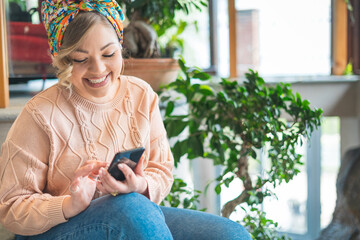 Pretty young curvy girl with beautiful smile checking his social post with the smartphone - Trendy girl monitoring his vending flower business online