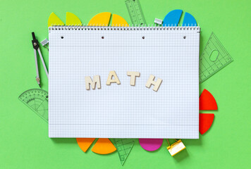 Wall Mural - Colorful math fractions, rulers, open notepad on a green background. Interesting, fun math for kids. Education, back to school concept