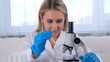 © Евгения Медведева - female scientist laboratory assistant uses micropipettes to fill test tubes in a large modern laboratory, for examination under a microscope.
