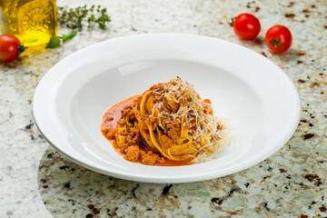 Poster - Pasta fettuccine Bolognese with meat and parmesan on white plate on marble table