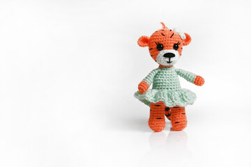 Wall Mural - Handmade amigurumi doll tiger cub in a dress is standing. Isolate, Copy space