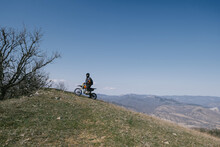 man riding offroad pit bike motorcycle in beautiful mountains hills landscape