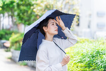 日傘をさす女性（紫外線対策・日焼け止め・UVケア・熱中症対策・日光アレルギー・体調不良）