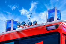 Close Up Of A Firefighter Truck With Blue Flash Against Blue Sky. Nahansicht Feuerwehrauto Mit Blaulicht