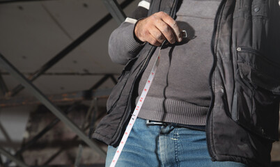 Wall Mural - Caucasian worker holding measure tape.