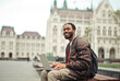 © olly - young man on a bench in the city with a computer
