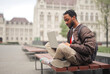 © olly - young man on a bench in the city with a computer