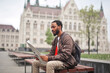 © olly - young man reads a newspaper on a bench