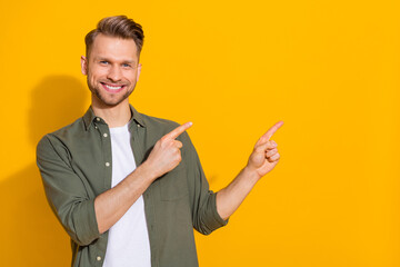Wall Mural - Portrait of attractive cheerful blond guy demonstrating copy empty space ad isolated over bright yellow color background