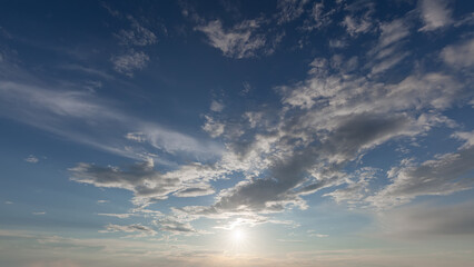 Blue sky with clouds with sun in counter light