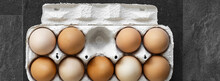 Brown Eggs In Carton Box On Dark Background.