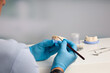 close-up of a dental technician painting dentures parts in dental laboratory