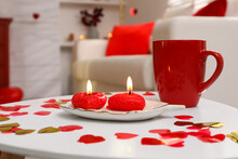 Red Cup, Candles And Heart Shaped Confetti On White Table Indoors. Valentine's Day Celebration