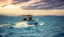 Fishing Boat Sails In Aegean Wavy Sea, Blue Sky At Sunset Background. Cyclades Greece.