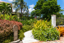 Sunbury Plantation House, Barbados. Tropical Garden And Old Mile Marker. Restored Great House From Gentry Time Of The Island's Sugar Barons. Built In The 1600s By Matthew Chapman An Early Settler. 