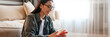 © Drobot Dean - White smiling woman using mobile phone while wrapping presents on floor